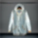 A stylish clear raincoat displayed on a hanger against a minimalist backdrop.